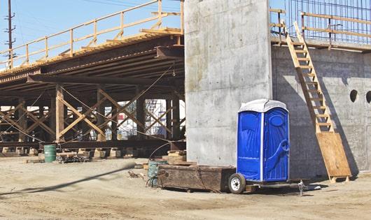 a lineup of sanitized porta potties on a busy construction site